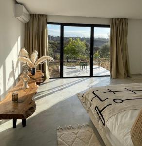 a bedroom with a large bed and a large window at Lahô Lodge in Lalla Takerkoust