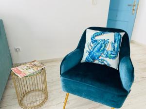 a blue chair with a pillow on it next to a table at Blue House Mallorca in Ses Salines