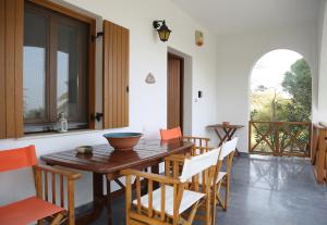 a dining room with a wooden table and chairs at Castello del Mare in Xerokampos