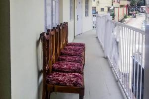 a row of wooden benches sitting on a balcony at Shillong Guest House in Shillong