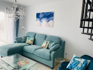 a blue couch in a living room with a glass table at Blue House Mallorca in Ses Salines