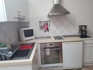uma cozinha com fogão e um computador no balcão em Maison de Line em LʼÎle-dʼOlonne