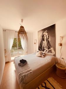 um quarto com uma cama com um quadro na parede em Noor apartamento em Begur