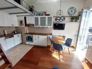 a kitchen with white cabinets and a table and chairs at JM Sopot Apartament Monte in Sopot