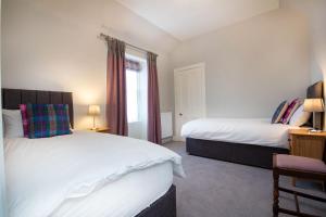 a bedroom with two beds and a window at Reay House in Nairn