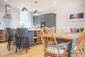 a kitchen and dining room with a wooden table and chairs at Reay House in Nairn