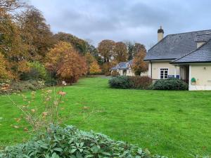 a house with a yard with green grass and trees at Mount Juliet luxury residence in Ballylinch Bridge