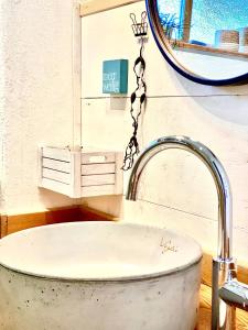 uma banheira na casa de banho com um espelho em Holmgård em Süderholm