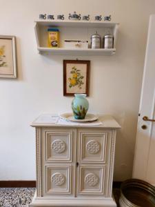 a white cabinet with a vase on top of it at San Gervasio Apartment in Venice