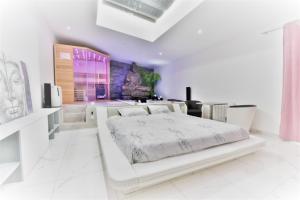 a white bedroom with a white bed in a room at Jacuzzi Romantique 15 min Etretat 2 in Fécamp