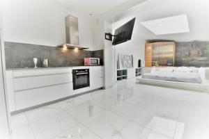 a kitchen with white cabinets and a bed in it at Jacuzzi Romantique 15 min Etretat 2 in Fécamp
