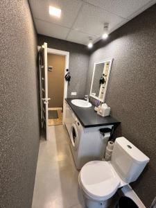 a bathroom with a white toilet and a sink at Draudzības alejas apartamenti in Jēkabpils