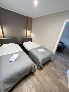 Dos camas en una habitación de hotel con toallas. en Draudzības alejas apartamenti, en Jēkabpils