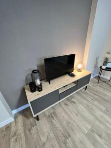 een flatscreen-tv zittend op een tafel bij Draudzības alejas apartamenti in Jēkabpils