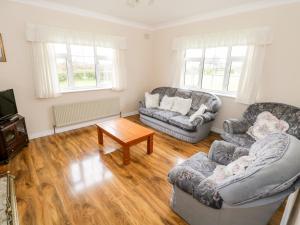 uma sala de estar com dois sofás e uma mesa de centro em Dromore West Cottage em Dromore West