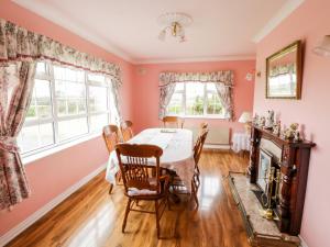 een eetkamer met een tafel en stoelen bij Dromore West Cottage in Dromore West