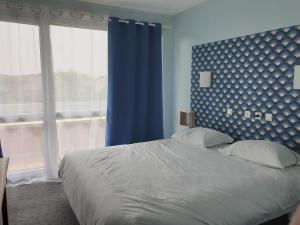 a bedroom with a large bed with a blue wall at Les Songes de Buxy in Buxy