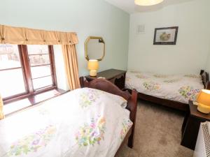 1 dormitorio con 2 camas y espejo en Church Farm Cottage, en Clifton