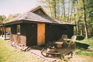 een kleine hut met een tafel en stoelen op een terras bij Viesu nams Melnsils in Melnsils