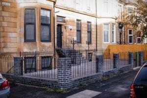 a building with a fence in front of it at S.H Apartments in Glasgow