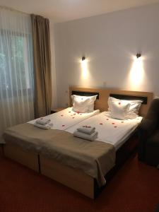 1 dormitorio con 1 cama con 2 toallas en Flora Alpina en Azuga