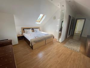 1 dormitorio con 1 cama grande y suelo de madera en Flora Alpina, en Azuga