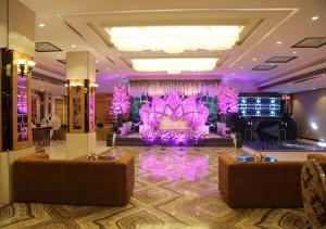 um salão de baile com uma grande sala com iluminação roxa em Lavanya Hotel- Near Alipur, Delhi em Nova Deli