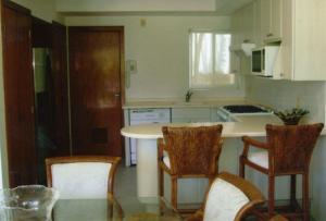 a kitchen with a table and four chairs in it at ACAPULCO Vidanta Villa alberca privada acceso playa in Acapulco