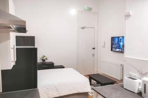 a bedroom with a bed and a tv on the wall at S.H Apartments in Glasgow