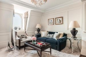a living room with a blue couch and two chairs at The Langham London in London