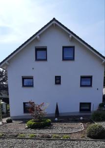 ein weißes Haus mit schwarzen Fenstern an der Seite in der Unterkunft Ferienwohnung Tintemann in Traben-Trarbach