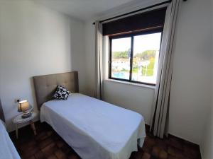 Habitación pequeña con cama y ventana en Apartamento V2 Pedro - By Bedzy, en Albufeira