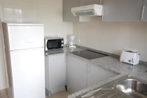 cocina con nevera blanca y microondas en Apartamento V2 Pedro - By Bedzy, en Albufeira