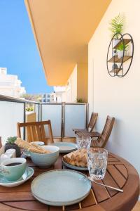 una mesa con platos y cuencos en la parte superior de un balcón en Casa di Flora Luxurious Apartment in Rhodes, en Rodas