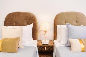 Dos camas con almohadas blancas y azules en un dormitorio. en Casa di Flora Luxurious Apartment in Rhodes, en Rodas