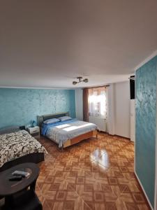 a bedroom with two beds and blue walls at Casa Cecilia in Costeşti