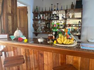 un bar con un plato de plátanos en un mostrador en Calou Guest House, en La Digue