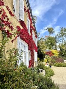 un bâtiment avec des fleurs rouges sur son côté dans l'établissement Le Clos des Erables, à Dijon