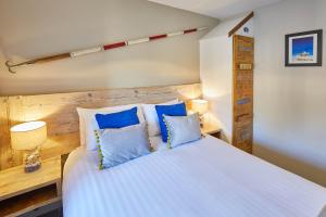 a bedroom with a white bed with blue pillows at Host & Stay - The Watchtower in Bamburgh +9 photos