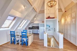 een keuken en eetkamer met blauwe stoelen en een tafel bij Host & Stay - The Watchtower in Bamburgh