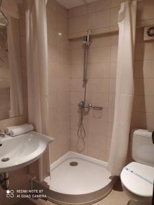 een badkamer met een douche, een wastafel en een toilet bij Spa Hotel Kleptuza in Velingrad