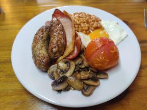 a plate of breakfast food with eggs sausage beans and mushrooms at Woolpack Inn in Chichester