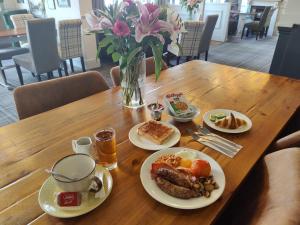a wooden table topped with plates of food and drinks at Woolpack Inn in Chichester