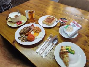 a wooden table with plates of breakfast food on it at Woolpack Inn in Chichester
