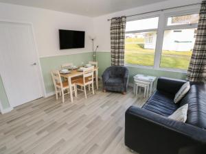 a living room with a couch and a table at Shearwater Chalet in Haverfordwest