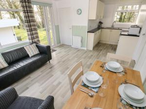 a living room with a table and a couch at Shearwater Chalet in Haverfordwest