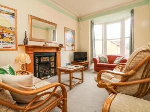 a living room with a fireplace and rocking chairs at Penryn in Ilfracombe