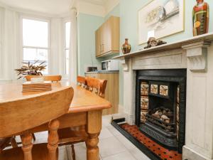 a kitchen with a fireplace and a dining room table at Penryn in Ilfracombe