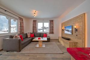 a living room with a couch and a table at Chalet Dorfkristall in Bramberg am Wildkogel