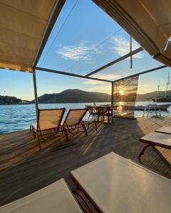 a deck of a boat with chairs and a table at Melisa Hotel in Bozburun